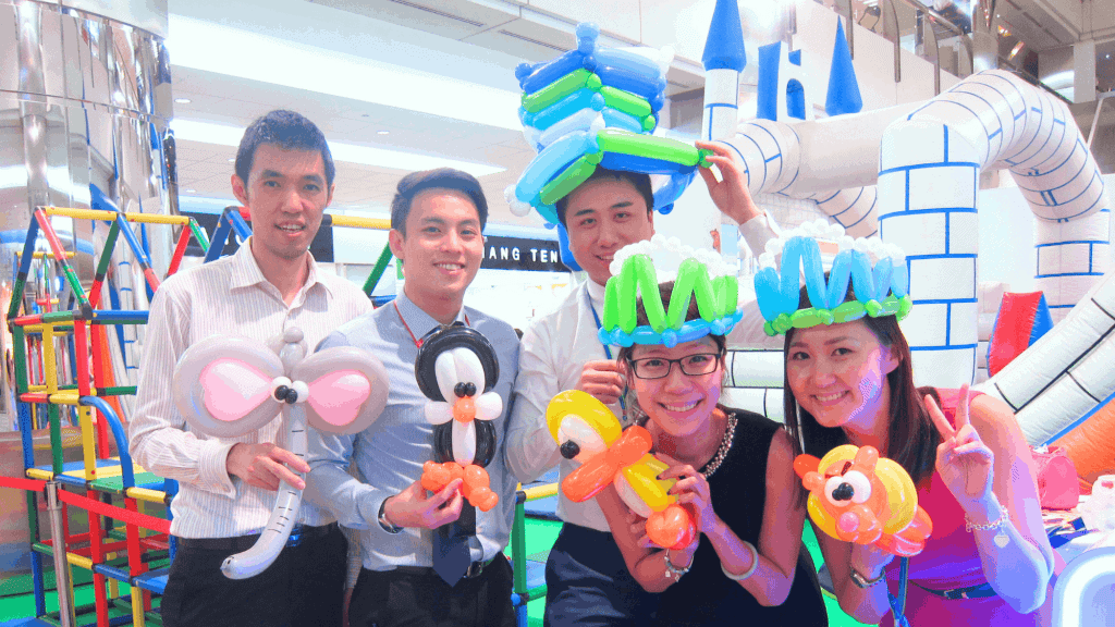 indoor-team-building-singapore-balloon-sculpting-activity Indoor team building activity in Singapore with colleagues holding balloon animal creations